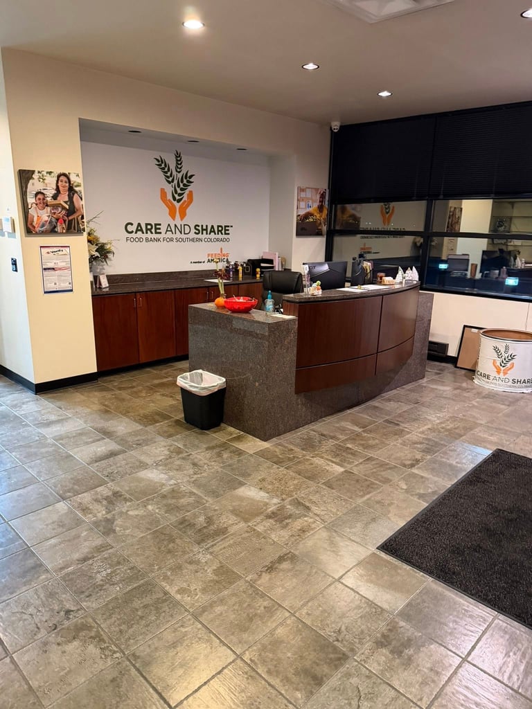 Modern medical office reception area with Care and Share logo, wooden desk counter, tiled flooring, and clinical workspace